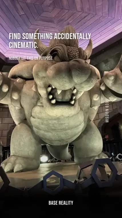 Base Reality mission 39, "Find something accidentally cinematic.", answered with a giant Bowser statue lit purple at night.